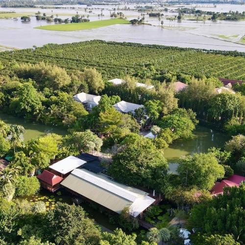 an aerial view of a farm with trees and water at Muaan Resort in Suphan Buri