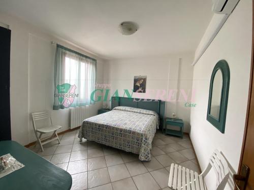 a bedroom with a bed and a table and a window at Campanile in San Vincenzo