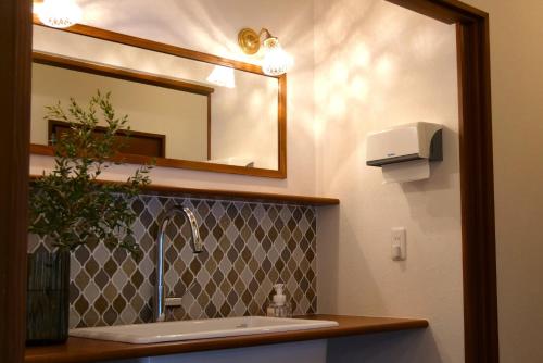 W łazience znajduje się umywalka i lustro. w obiekcie women only ulala guesthouse - Vacation STAY 58434v w mieście Hagi