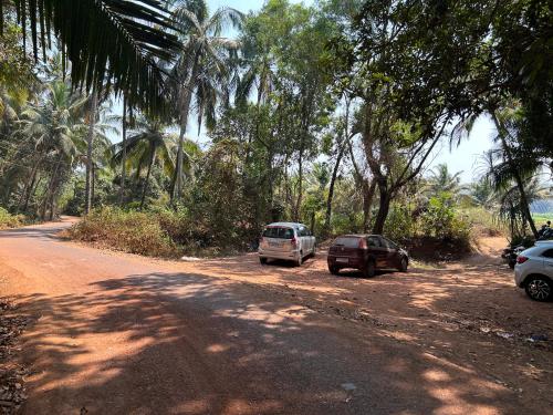two cars parked on the side of a dirt road at Shivam Bnb Mandrem Resort in Mandrem