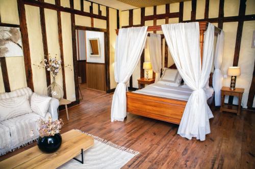 a bedroom with a bed with curtains and a couch at Cafe de france Eauze in Eauze