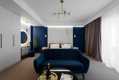 a blue bedroom with a bed and a blue couch at Luxury Saphir Gold Mamaia Nord in Mamaia
