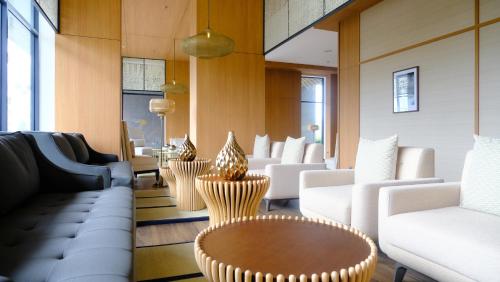 un vestíbulo con sillas blancas y una mesa en Hotel Osaka PIK2, en Tangerang