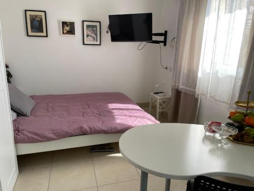 een kleine slaapkamer met een bed en een tafel bij my holiday apartment in Zikhron Ya‘aqov