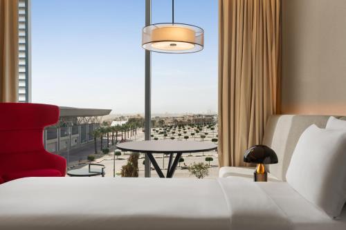 a hotel room with a bed and a table and a window at Radisson Blu Hotel Riyadh Convention and Exhibition Center in Riyadh