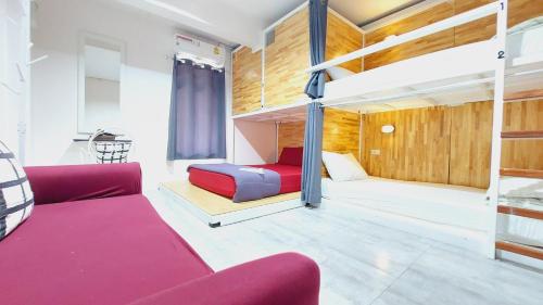 um quarto com duas camas e um sofá vermelho em Neat Hostel em Chiang Mai