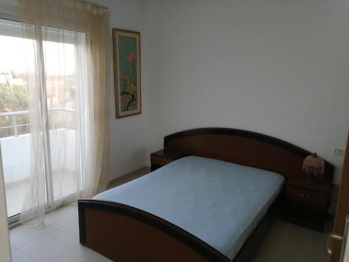 a bedroom with a bed and a window at résidence familiale CORAIL in Chott Meriem