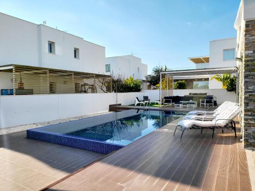 a backyard with a swimming pool and a house at Villa utopia in Paphos City
