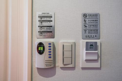 a door with an electronic device and signs on it at Hub Hotel - Songshan Airport Branch in Taipei