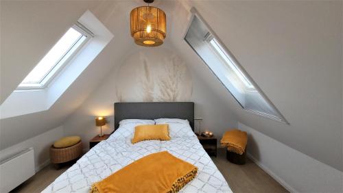 a attic bedroom with a bed and two windows at Sonneninsel & Ankerplatz Wiek in Wiek auf Rügen 