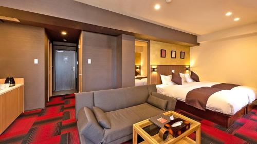 ein Hotelzimmer mit einem Bett und einem Sofa in der Unterkunft Stay SAKURA Tokyo Asakusa Edo no Mai in Tokio