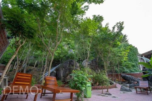 a picnic table and chairs in a garden with trees at Thien Thanh Hotel in Phong Nha