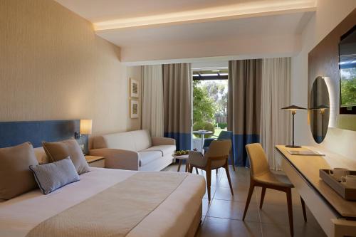 a hotel room with a bed and a living room at Mediterranean Beach Hotel in Limassol