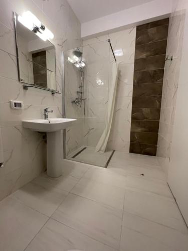 a white bathroom with a shower and a sink at NEW Central nr1 Self Checkin OldCity Center Paid Parking with Lift in Timişoara