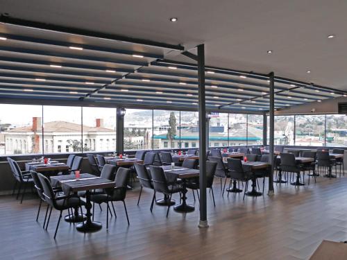 - une salle à manger avec des tables, des chaises et des fenêtres dans l'établissement GRAND ÜSKÜDAR OTEL, à Istanbul