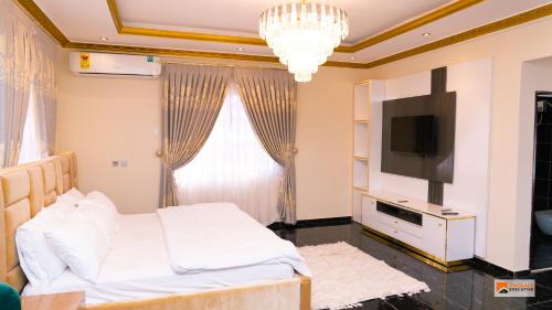 Schlafzimmer mit einem Bett und einem Flachbild-TV in der Unterkunft Zackai Executive Guest house in Mlichakpo