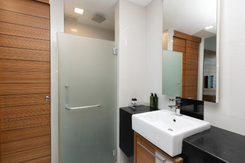 a bathroom with a white sink and a mirror at Dua Sentral Residence near KL Sentral by COBNB in Kuala Lumpur
