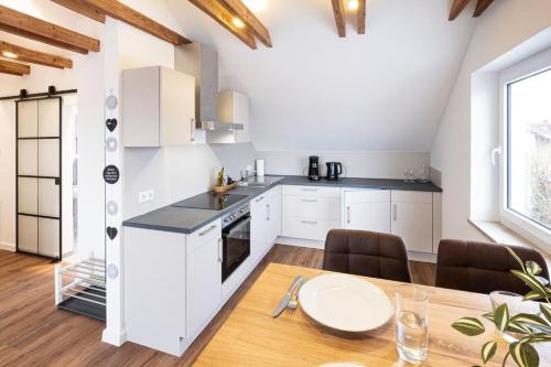 a kitchen with white cabinets and a table and chairs at Gemütliches Loft-Retreat in Treuchtlingen