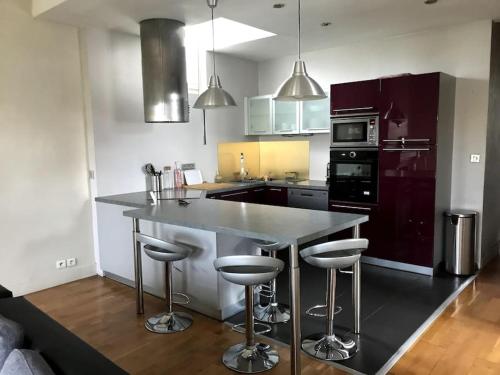 a kitchen with a large island with bar stools at Appartement 5min à pied du centre-ville Bayonne in Bayonne