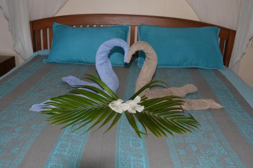 un lit avec deux cygnes et une plante sur lui dans l'établissement Villa MERAHI ... La villa d'Ange Fare Noa Mymy, à Uturoa