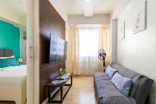 a living room with a couch and a bed at Functional 1-br Space in Amaia with Fast Internet in Mandaue City