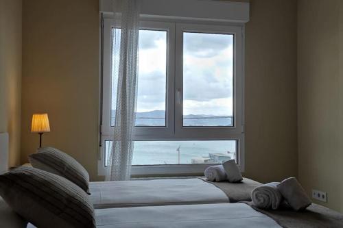 - une chambre avec une grande fenêtre donnant sur l'océan dans l'établissement C01A05 Precioso apartamento con vistas al mar, à Santander