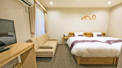 京都市にあるStay SAKURA 京都 御苑東のベッド2台とテレビが備わるホテルルームです。