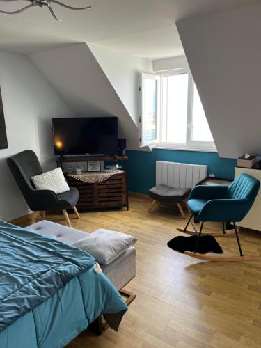 - une chambre avec un lit, une télévision et des chaises dans l'établissement Rose d'Écumes, à Tréffiagat