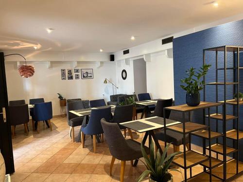 a dining room with tables and blue chairs at Guest House Kolarin in Slano