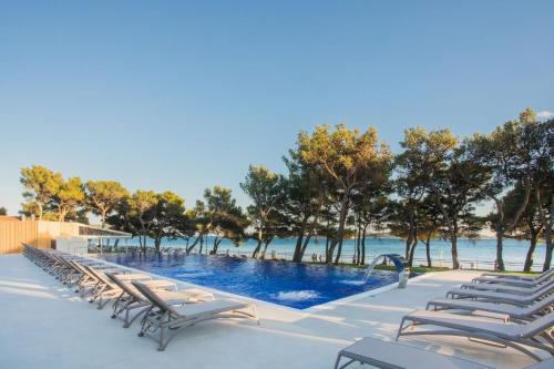 een rij ligstoelen naast een zwembad bij Villa Arausa in Vodice