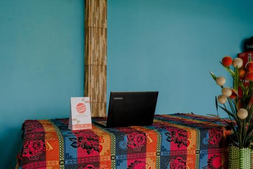 a laptop computer sitting on top of a bed at OYO 1784 Hj. Aniek Residence in Madiun