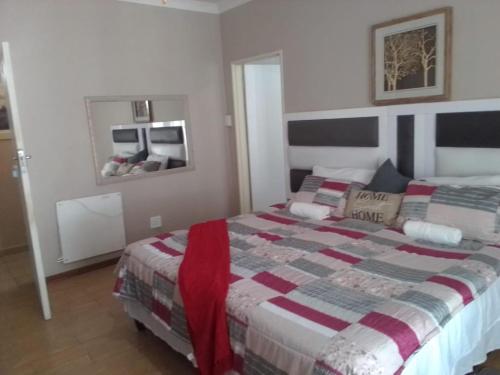 1 dormitorio con 1 cama con edredón en THATCH HAVEN GUEST HOUSE en Mafikeng