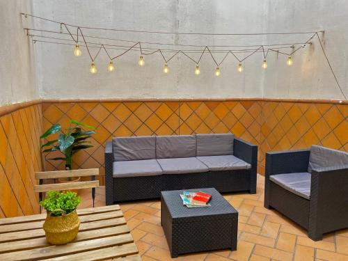 un patio con sofá, 2 sillas y una mesa en Apartamento Armas - Ole Solutions, en Jerez de la Frontera