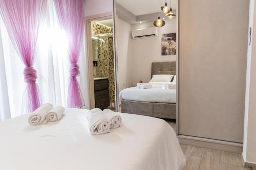 1 dormitorio con 2 camas, cortinas rosas y espejo en Piraeus Port Exclusive, en Pireo