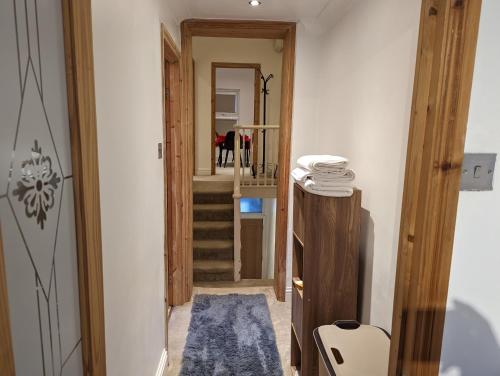 un corridoio con una scala con un tappeto blu di Fully-equipped flat in the city of London a Londra