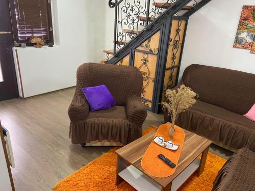 a living room with two chairs and a table at Stan na dan Gornji Milanovac-centar-Nova gradnja in Gornji Milanovac