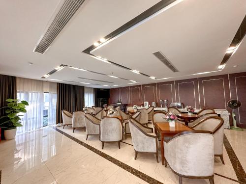 a restaurant with chairs and tables in a room at Linh Trang Hạ Long Hotel in Ha Long