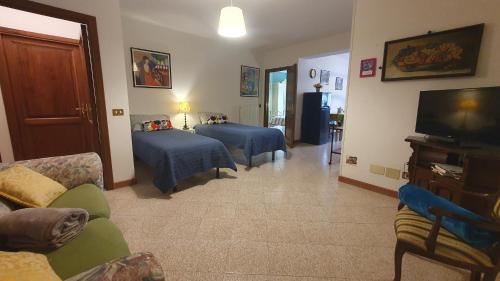 a living room with two beds and a television at Le Casette di Civitella la casa di Nonna Giulia in Civitella Del Lago