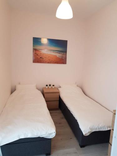 duas camas num quarto com uma fotografia na parede em Apartament na Zaciszu em Kąty Rybackie