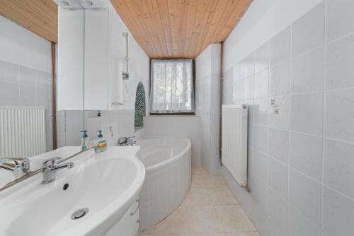 a white bathroom with a tub and a sink at Schloss Berg Klösterle in Zedlitzdorf