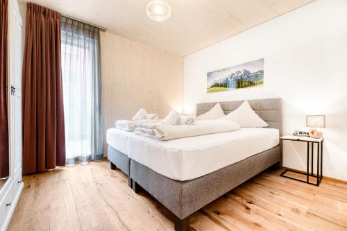 - une chambre avec un grand lit et une grande fenêtre dans l'établissement Familienferienwohnung Zentral by A-Appartments, à Brand