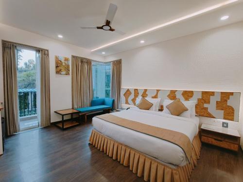 Ataraxia Crestmont Resort & Spa في دهرادون: غرفة نوم بسرير كبير وكرسي ازرق