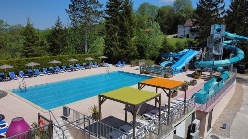 a large swimming pool with a water slide at camping Le moulin in Patornay
