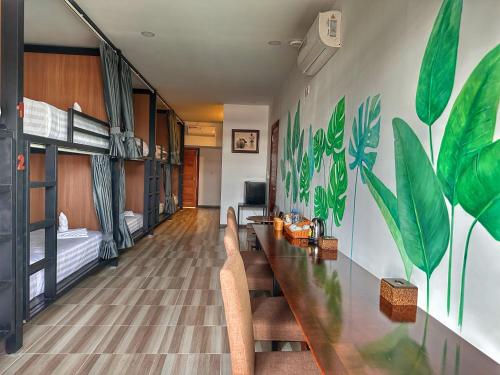 a room with a long table with chairs and a bedroom at Monsoon Riverside Hotel in Phnom Penh