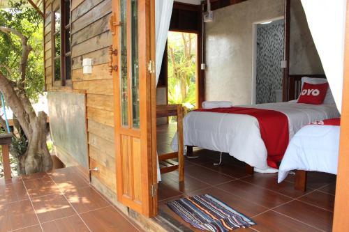 a bedroom with a bed and a sliding glass door at OYO 75419 Baan Suan Mulberry Farmstay in Hua Hin