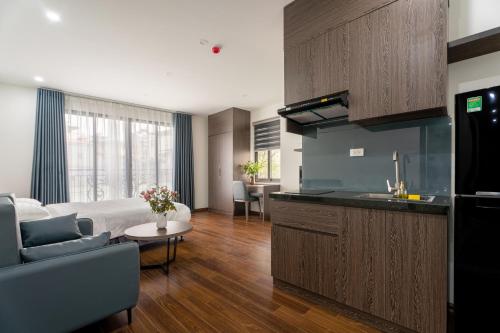 uma cozinha e sala de estar com uma cama e um sofá em Granda Lake View Hotel & Apartment em Hanói