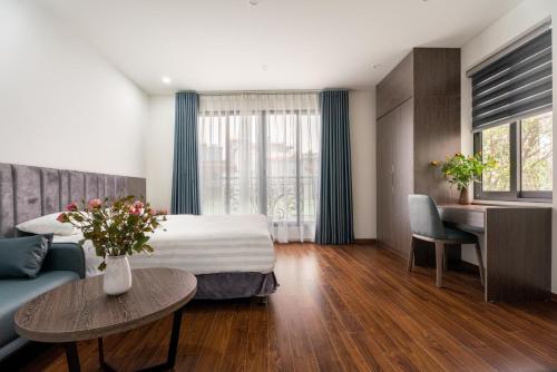 um quarto de hotel com uma cama, um sofá e uma mesa em Granda Lake View Hotel & Apartment em Hanói