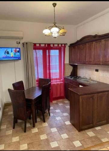 una cucina con tavolo in legno e una sala da pranzo di Mediterranean Downtown Apartment a Arad