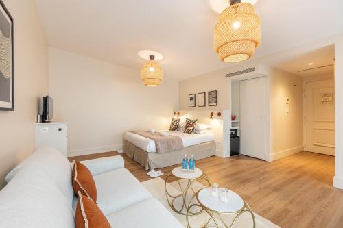 salon z łóżkiem i kanapą w obiekcie Le Nest by Sweet Inn w Paryżu