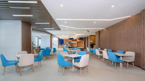 a dining room with blue and white chairs and tables at Holiday Inn Express Chengdu Tianfu Airport Zone, an IHG Hotel in Jianyang